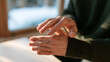 © Nova Zigres - Anonymous Man with Rheumatoid Arthritis Examining Swollen Fingers and Joint Stiffness