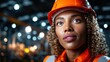 © Larisa AI - A determined female engineer wearing an orange safety helmet, displaying confidence and focus while surrounded by a blurred, dynamic industrial environment that represents strength.