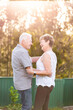 © Austockphoto - older Australian couple smiling together holding hands outdoors in golden light