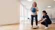 © ali - Senior woman doing physical therapy exercise with balance board and medicine ball, assisted by female physiotherapist in bright clinic interior, healthcare concept