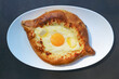 © jobi_pro - Mouthwatering Adjarian Khachapuri, a Cheese and Egg Filled Traditional Georgian Bread