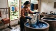© starush - Indonesian artisan dyes wax-resist cloth in indigo