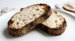 © Fakhri - Two Slices of Freshly Toasted Artisanal Sourdough Bread with a Crispy Charred Crust and Open Crumb Texture Served on a Minimalist White Plate for a Healthy Morning Breakfast or Gourmet Snack