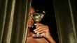 © overrust - luxurious martini cocktail behind velvet curtains, elegant hand holding crystal martini glass, sophisticated cocktail bar with dramatic velvet curtains