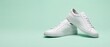 © image studio - A pair of clean white leather sneakers isolated against a solid light green background with sneakers positioned together background studio product together flat surface with against soft mint, fashion