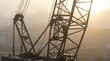 © Selasa - Construction crane silhouetted in thick morning fog.