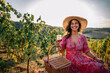 © Mediteraneo - Woman sitting in vineyard with picnic basket and glass of red wine