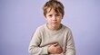 © Dzianis - sad young white boy in a warm sweater holding his stomach while experiencing abdominal pain and nausea against a purple background