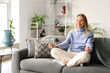 © Pixel-Shot - Mindfulness and mental health, woman practicing meditation and yoga on a sofa at home to reduce stress and improve emotional well being in a cozy room