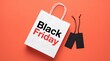 © MDZAHANGIR - White shopping bag with black friday text and price tags on orange background