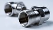 © Daria - Two shiny metallic threaded fittings for plumbing or machinery, showcasing precise engineering details and smooth surfaces in a professional product shot