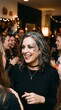 © Zanzaa - A woman with Halloween makeup smiles at a party. She has glittery spiderweb makeup on her cheek and her hair is gray