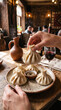 © tangmo.pa - Hand holding hot traditional Georgian khinkali dumpling in rustic restaurant