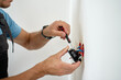 © Lazy_Bear - Person installing electrical outlet in wall at home