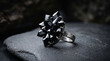 © BaqirAli - Jewelry featuring an elaborate black crystal ring displayed artfully on natural dark stone blocks.