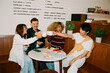 © Júlia Amaral - Young business toast with coffee in a cozy cafe