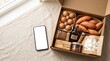 © Rahila - Autumn grocery delivery box with sweet potatoes eggs baking ingredients and blank smartphone