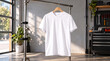 © Lukman - Blank white t-shirt hanging on a wooden hanger as a mockup in a modern industrial loft style workspace with tools and plant decor in the background