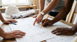 © Rozaq - Diverse team collaborating on construction blueprint, project planning
