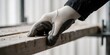 © MT - Worker wearing safety glove touching wooden plank on a construction site representing manual labor protection and industry work