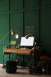 © Pixel-Shot - Remote work and software development, programmer workspace with computer and tablet in a modern home office with dark green wall and gold decor