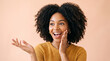 © KAMRAN - Delighted woman with hand on cheek showing surprised expression on peach backdrop perfect for emotional storytelling and cheerful brand messaging