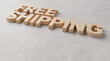 © HSR - Free shipping wooden letters lying on a grey stone surface