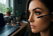 © Pixel-Shot - Beauty routine and remote work, woman applying mascara at home office desk with laptop and cosmetics for morning preparation and self care lifestyle