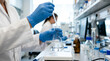 © Andra - Scientist performs liquid transfer in laboratory with beakers and equipment