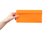 © fotofabrika - Hand holding an orange envelope in front of a plain background