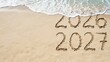 © Habiba Noor  Jannat - 2026 and 2027 written in the sand on a beach with ocean waves