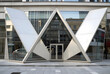 © Pixel-Shot - Modern architecture and corporate office design, geometric glass facade with triangular entrance of a contemporary commercial building in urban setting