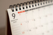 © daily_creativity - Close up of a spiral bound desk calendar showing September 2026 with the first dates of the month in soft side light, shallow depth of field, concept of monthly planning, autumn schedule and back to