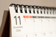 © daily_creativity - Close up of a spiral desk calendar page for November 2026 with large number 11 and red Sunday dates in warm soft light, concept of end of year planning, November schedule and deadlines