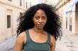 © ADDICTIVE STOCK - Confident woman with curly hair on a city street