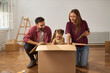© Goran - Happy family packing their belongings into cardboard boxes