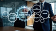 © miss irine - Businessman uses futuristic hologram interface with gear icons for digital marketing strategy. Pro executive manages online optimization, social media, web analytics in modern office. Virtual tech