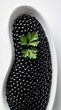 © miss irine - Black caviar in white oval dish with green parsley garnish. Top view of premium sturgeon roe. Luxury seafood delicacy on bright background. Elegant gourmet appetizer for fine dining special