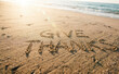 © velikiyzayats - Give thanks message written on sandy beach at ocean shore during sunset for gratitude concept and holiday celebration