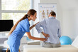 © Pixel-Shot - Physical therapy and back pain treatment, physiotherapist examining patient with lower back injury in medical clinic office for rehabilitation care