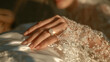 © Jeongsuk - Close-up of bride hand wearing sparkling diamond wedding ring on lace sleeve