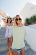 © Iryna - Two women summer fashion in pastel casual outfits on white mediterranean stairs background for lifestyle banner and social media promotion