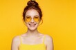 © miss irine - Happy young redhead woman wears yellow round sunglasses, bright face paint. Smiling girl poses against solid yellow background. Summer fashion look with colorful makeup, trendy eyewear for creative