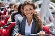 © YouraPechkin - Young woman in business attire smiling while riding a roller coaster at amusement park