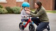 © Cahya - Mother fitting blue safety helmet and chin strap on young daughter riding balance bike on street conveying child cycling safety protection and outdoor activity prep