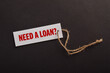 © Mulad Images - Loan concept featuring a labeled tag on a dark background, representing borrowing, credit, personal finance, financial assistance, lending, and funding needs.