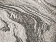 © donaldsamuel - A distinctive, abstract, and curving surface pattern resembling flowing water or swirls (marbling effect), featuring white, light gray, and dark gray tones alongside thick black veins.