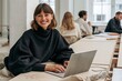 © Breezze - Businesswoman typing on a brushed aluminum laptop in a bright office, smiling with confident ease for teamwork and success concepts