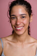 © Metadancer - Young Hispanic woman smiling in a beauty shoot with pink background
