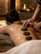 © Porpuhedja - Woman receiving a hot stone massage therapy treatment at a luxury spa